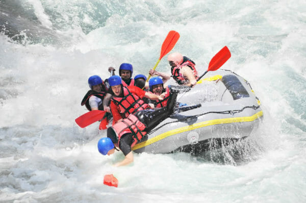photo of whitewater raft tipping over