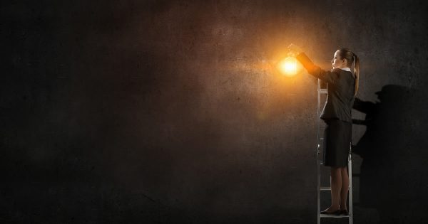 Helping our leaders lead during COVID-19 (illustration of felae leader with lantern in darkness)